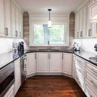 Large transitional kitchen pantry designs - Example of a large transitional galley medium tone wood floor and brown floor kitchen pantry design in Wichita with an undermount sink, raised-panel cabinets, white cabinets, quartzite countertops, multicolored backsplash, limestone backsplash, stainless steel appliances and an island