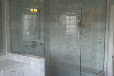 Photo of a large modern master bathroom in Denver with raised-panel cabinets, white cabinets, a corner shower, gray tile, ceramic tile, white walls, porcelain floors, marble benchtops, beige floor and a hinged shower door.