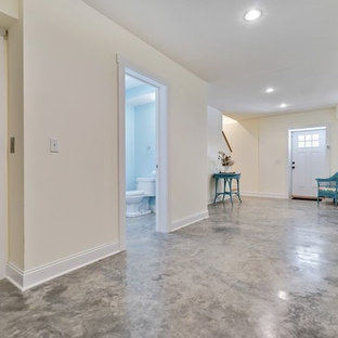 Photo of a large traditional walk-out basement in New York with yellow walls, concrete flooring and no fireplace.