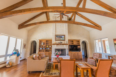 Inspiration for a large timeless formal and open concept dark wood floor living room remodel in Austin with beige walls, a standard fireplace, a stone fireplace and a media wall