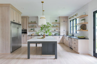 Enclosed kitchen - mid-sized farmhouse galley medium tone wood floor enclosed kitchen idea in DC Metro with an undermount sink, shaker cabinets, medium tone wood cabinets, quartz countertops, beige backsplash, cement tile backsplash, stainless steel appliances, an island and white countertops