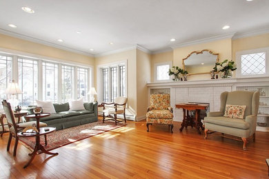 Mid-sized elegant formal and enclosed light wood floor living room photo in Chicago with yellow walls, a standard fireplace and a brick fireplace