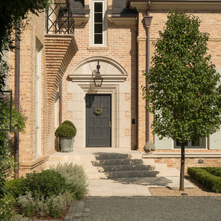 Пример оригинального дизайна интерьера: входная дверь в классическом стиле с красными стенами, одностворчатой входной дверью, серой входной дверью и бежевым полом