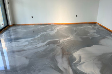 Example of a minimalist concrete floor family room design in Other