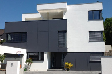 Großes, Zweistöckiges Modernes Einfamilienhaus mit schwarzer Fassadenfarbe, Mix-Fassade, Flachdach und Blechdach in Sonstige