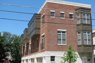 Example of a large classic three-story brick flat roof design in Chicago