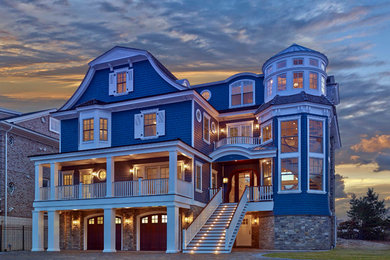 Photo of a large beach style three-storey blue exterior in DC Metro with wood siding.