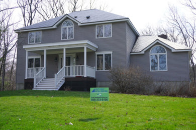 Example of a mid-sized classic two-story house exterior design in Boston with a hip roof and a metal roof