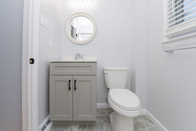 Inspiration for a small powder room remodel in Other with gray cabinets, gray walls and an integrated sink