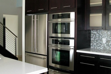 Foto de cocina moderna grande con armarios con paneles lisos, puertas de armario de madera en tonos medios y una isla