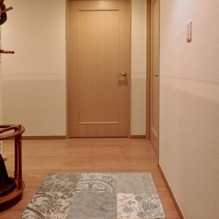 Exempel på en liten klassisk hall, med beige väggar, plywoodgolv och brunt golv