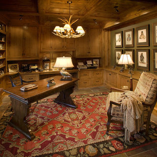 This is an example of a traditional home office in Minneapolis with green walls and a freestanding desk.