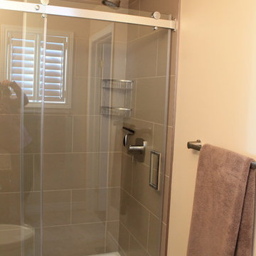 Large offset tile, invisible drain and rolling glass door.