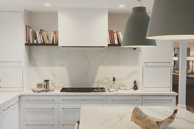 Kitchen - mid-sized contemporary kitchen idea in Atlanta with flat-panel cabinets, white cabinets, solid surface countertops, white backsplash, stone slab backsplash, an island and white countertops