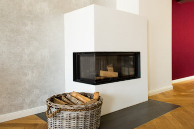 Großes, Offenes Modernes Wohnzimmer mit weißer Wandfarbe, gebeiztem Holzboden, Eckkamin, verputzter Kaminumrandung und braunem Boden in Stuttgart