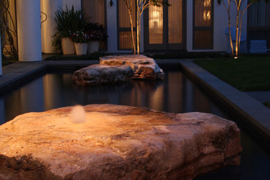 Design ideas for a contemporary pool in Houston with a water feature.