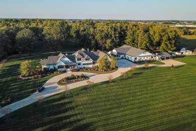 Large cottage white two-story wood and clapboard exterior home photo in Other with a shingle roof and a gray roof