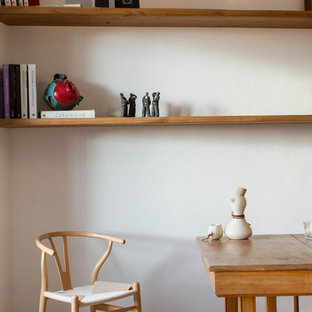 カリアリの小さい北欧風 LDKの画像 (白い壁、ラミネートの床、コーナー設置型暖炉、金属の暖炉まわり)