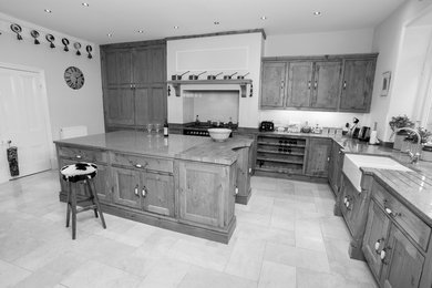 Large traditional l-shaped kitchen/diner in Other with an integrated sink, recessed-panel cabinets, medium wood cabinets, granite worktops, black appliances, ceramic flooring and an island.