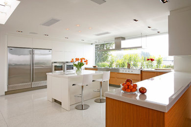 Kitchen - contemporary u-shaped kitchen idea in Los Angeles with flat-panel cabinets, medium tone wood cabinets and stainless steel appliances