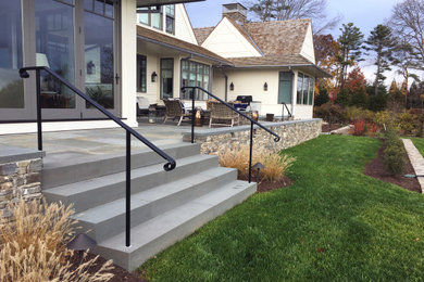Inspiration for a large timeless backyard stone patio remodel in Providence with a fire pit and no cover