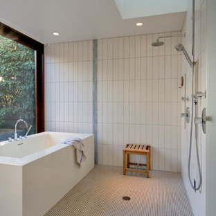 Immagine di una stanza da bagno minimalista con vasca freestanding, piastrelle bianche, pavimento con piastrelle a mosaico e doccia a filo pavimento