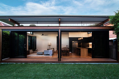 Photo of a large contemporary backyard partial sun garden in Sydney with decking.