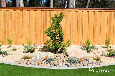 This is an example of a mid-sized traditional drought-tolerant and full sun backyard concrete paver landscaping in San Diego for summer.