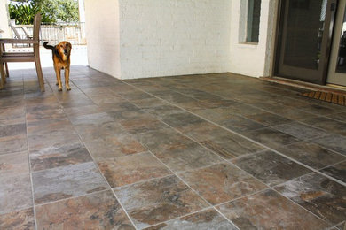 Large elegant backyard tile patio photo in Austin with a roof extension