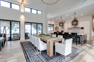 Inspiration for a mid-sized modern laminate floor and brown floor eat-in kitchen remodel in Other with a single-bowl sink, flat-panel cabinets, white cabinets, quartz countertops, white backsplash, quartz backsplash, stainless steel appliances, an island and white countertops