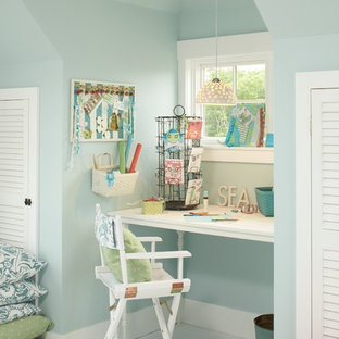 Modelo de sala de manualidades costera, de tamaño medio, sin chimenea, con paredes beige, suelo de baldosas de porcelana, suelo blanco y escritorio independiente