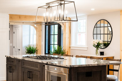 Kitchen - large cottage light wood floor kitchen idea in Portland Maine with a farmhouse sink, shaker cabinets, dark wood cabinets, marble countertops, an island and gray countertops