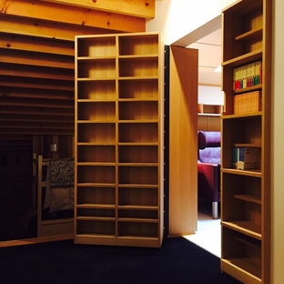 This is an example of a modern home office and library in Other with a reading nook, white walls, carpet, no fireplace, a built-in desk and black floors.
