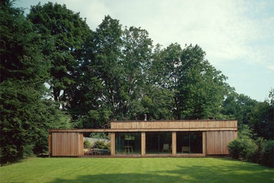 Example of a mid-sized brown one-story wood flat roof design in New York
