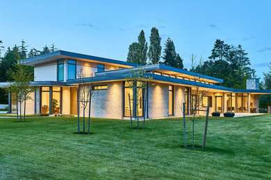 Inspiration for a large contemporary gray two-story concrete exterior home remodel in Other with a mixed material roof