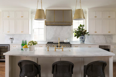 Inspiration for a transitional eat-in kitchen remodel in Houston with an undermount sink, shaker cabinets, white cabinets, marble countertops, white backsplash, stone slab backsplash, stainless steel appliances and an island