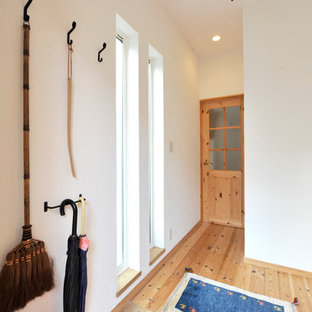 他の地域のモダンスタイルのおしゃれな玄関 (白い壁、テラコッタタイルの床、オレンジの床) の写真