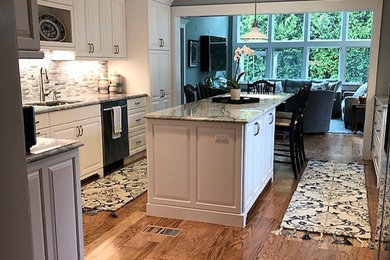 Elegant medium tone wood floor kitchen photo in Other with an island and white countertops