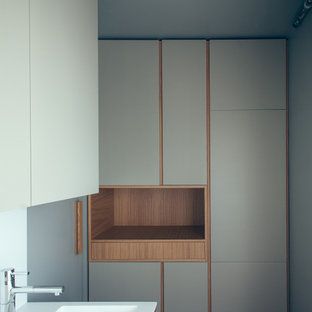 Small modern kitchen pantry pictures - Kitchen pantry - small modern single-wall ceramic floor kitchen pantry idea in Milan with flat-panel cabinets, light wood cabinets, solid surface countertops, white backsplash and stainless steel appliances