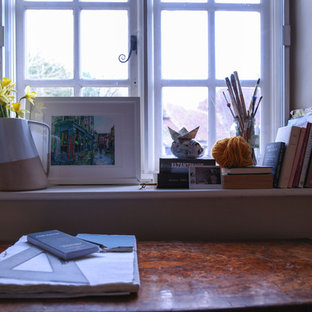 Foto di un atelier country di medie dimensioni con pareti beige, moquette, scrivania autoportante e pavimento verde