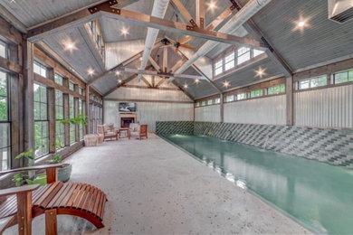 Example of a mid-sized mountain style indoor concrete paver and rectangular lap pool house design in Other