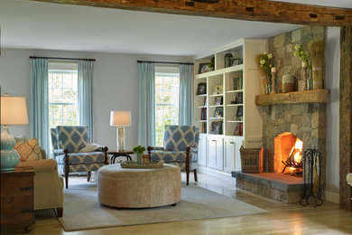 Photo of a mid-sized country formal living room in Portland Maine with grey walls, light hardwood floors, a standard fireplace, a stone fireplace surround, no tv and exposed beam.