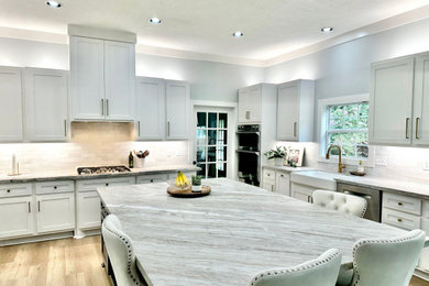 Kitchen - transitional light wood floor kitchen idea in Houston with shaker cabinets, gray cabinets, granite countertops, white backsplash and ceramic backsplash