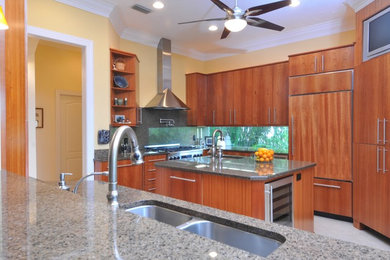 Mid-sized minimalist u-shaped porcelain tile and beige floor enclosed kitchen photo in Tampa with an undermount sink, flat-panel cabinets, medium tone wood cabinets, granite countertops, gray backsplash, stone slab backsplash, stainless steel appliances and an island