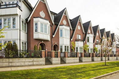 Mid-sized elegant brown two-story brick exterior home photo in Vancouver with a shingle roof