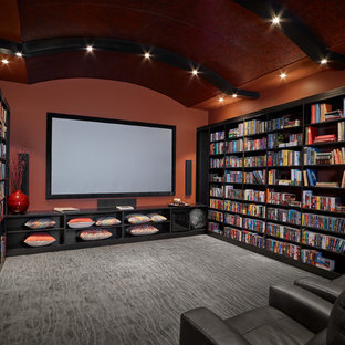 Réalisation d'une grande salle de cinéma tradition fermée avec un sol en bois brun, un mur orange, un téléviseur fixé au mur et un sol gris.