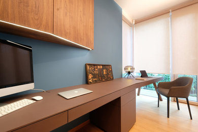 Großes Klassisches Arbeitszimmer mit Arbeitsplatz, blauer Wandfarbe, Laminat, freistehendem Schreibtisch und braunem Boden in München