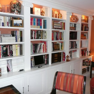 Photo of a mid-sized traditional home office in Boston with a library, orange walls, carpet, no fireplace and a freestanding desk.