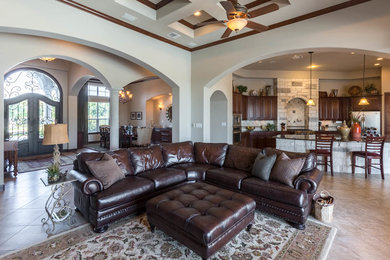 Inspiration for a mid-sized southwestern open concept travertine floor family room remodel in Austin with beige walls, a corner fireplace, a stone fireplace and a media wall