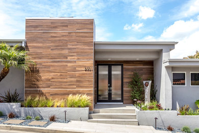This is an example of a large midcentury one-storey stucco grey exterior in Los Angeles.
